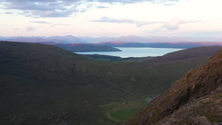 Aerial view of the Jagged Mountains, Lochs and Sea on the Isle of Skye, Scotland UK at Sunset with Colourful Skies. Hiking and camping in the Cuillin Mountains. 