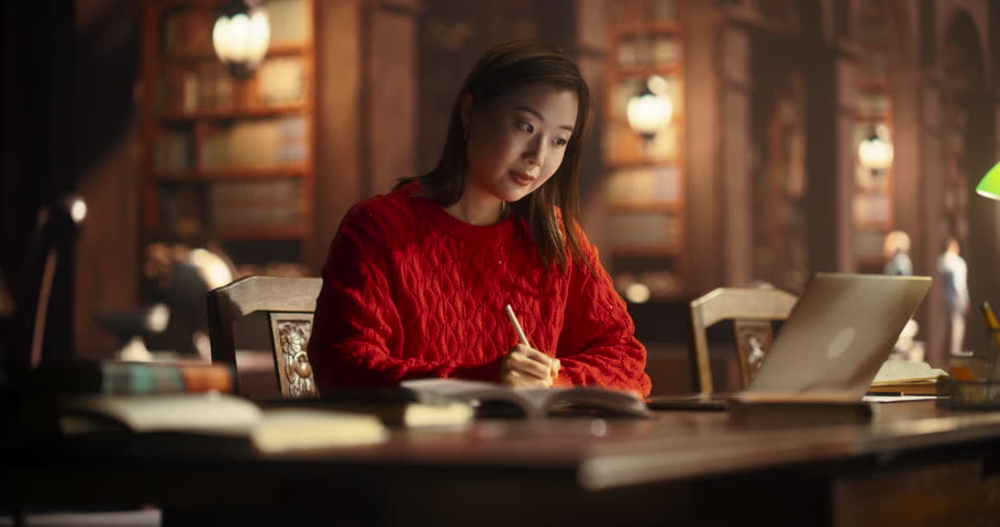 Attractive Multiethnic Student Making a STEM Class Homework in a Textbook, While Researching Quiz Answers on a Laptop Computer. Young Asian Female Studying in a Public Library with Classical Interior Royalty-Free Stock Footage #1107760585