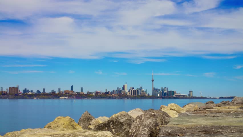 View from shore to harbor surrounded huge skyscrapers and CN Tower, Toronto. Calm atmosphere on harbor far from city life. Concept recreate mental health on harbor lake far from skyscrapers, city life
