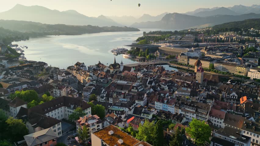 Aerial morning view of Lucerne old town and Reuss river. Flying over watchtowers and city wall in Luzern, Switzerland. Swiss Alps on background Royalty-Free Stock Footage #1107762749