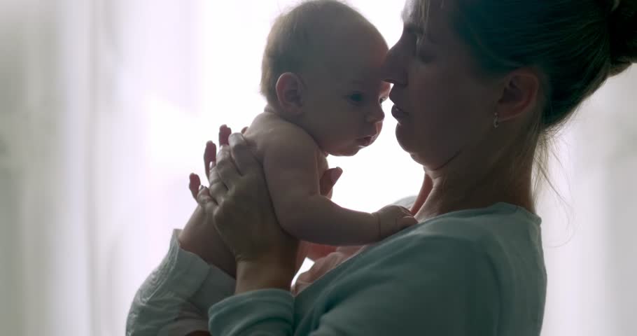 silhuette mommy hugging her son, tries to calm the crying baby, shakes him in her arms, dissatisfied, crying, upset, sad Newborn baby boy on mother hands at home. Royalty-Free Stock Footage #1107770073