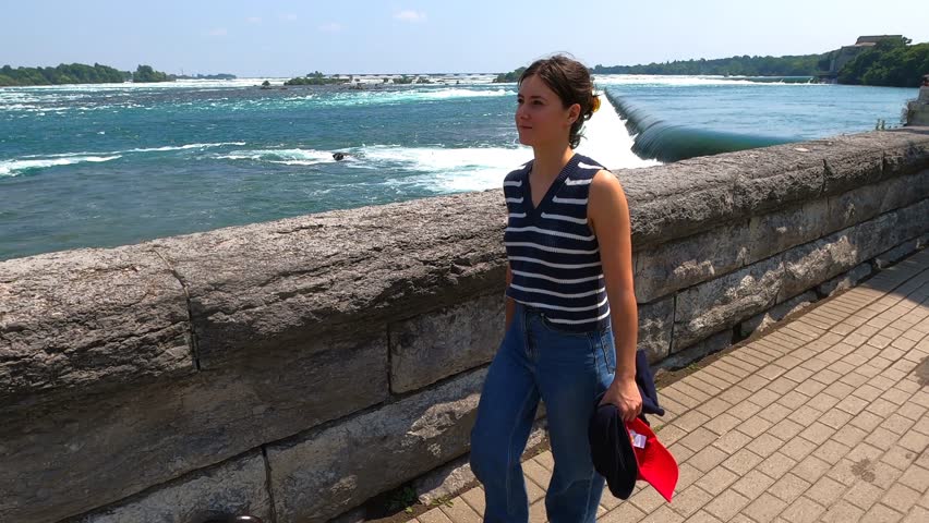 A beautiful young woman strolling along the Niagara River.