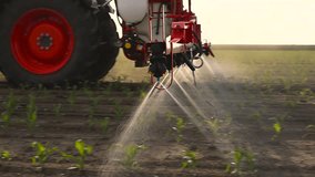  close-up of a tractor spraying pesticides on corn field  with sprayer at spring - Powered by Shutterstock - Get 15% off with code: PIKWIZARD15