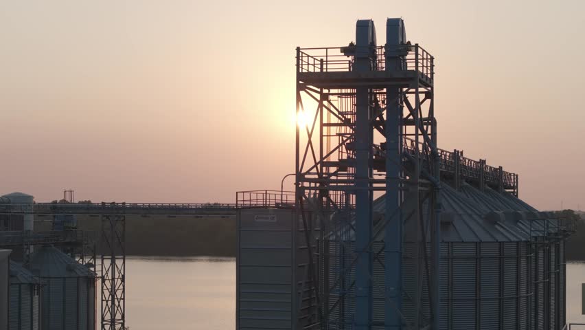 The sun rises behind a rice mill in Arkansas on the Arkansas River.