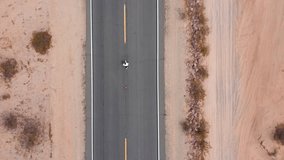 Walking on desert dusty dirt road. man walking away down a rural road. Aerial vertical, vertical video background. 