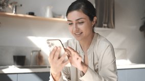 Happy woman smiling looking at camera. Home office interior. Business woman closeup portrait. Girl using smartphone internet surfing communication online. Pretty woman holding phone. Tapping, swiping