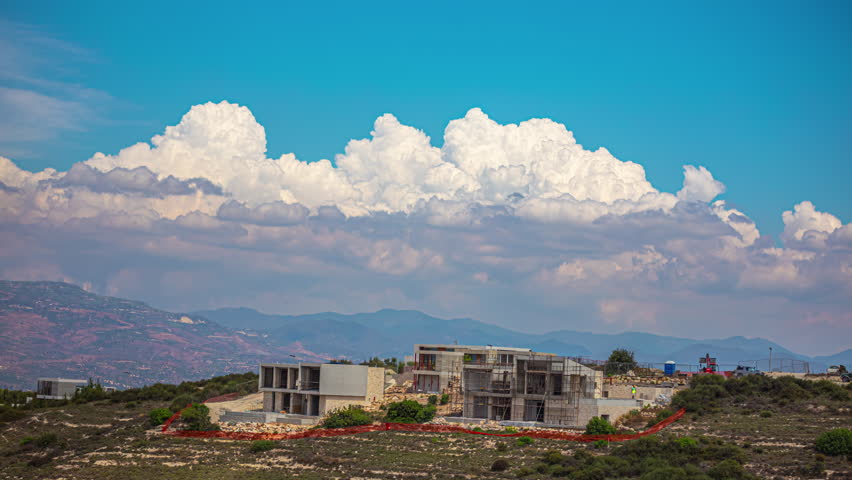 Timelapse of Puffy White Clouds Forming Over the Landscape of Cyprus with Buildings Under Construction.
