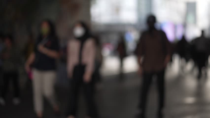 Blurred anonymous citizens of jakarta walking in a tunnel