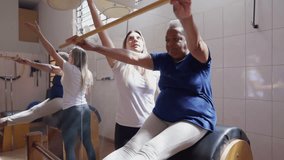 African American Senior woman exercising in Pilates class session with the help of instructor. A black Elderly person workout routine, stretching body - Powered by Shutterstock - Get 15% off with code: PIKWIZARD15