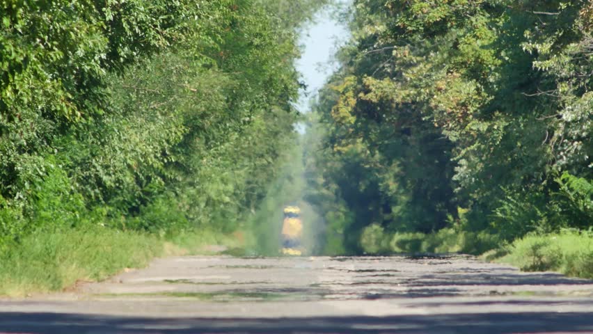 Heat haze and mirage over road on hot summer day. Truck drives along road surrounded by green trees. Period of abnormally hot weather and extreme heat. Global warming and climate change concept video