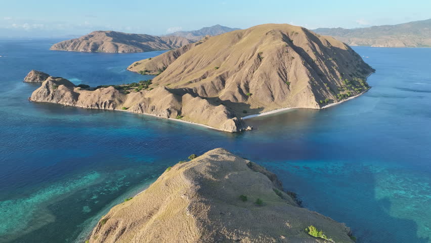 Beautiful coral reefs fringe the scenic island of Gili Lau Laut in Komodo National Park, Indonesia. This island's coral reefs harbor extraordinary marine biodiversity and are often visited by divers.  Royalty-Free Stock Footage #1107805935