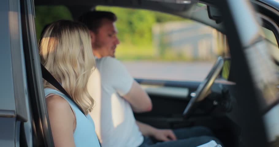 Young man and driving school instructor with clipboard talking in car. Man listening to instructor in car learning to drive. Royalty-Free Stock Footage #1107807005