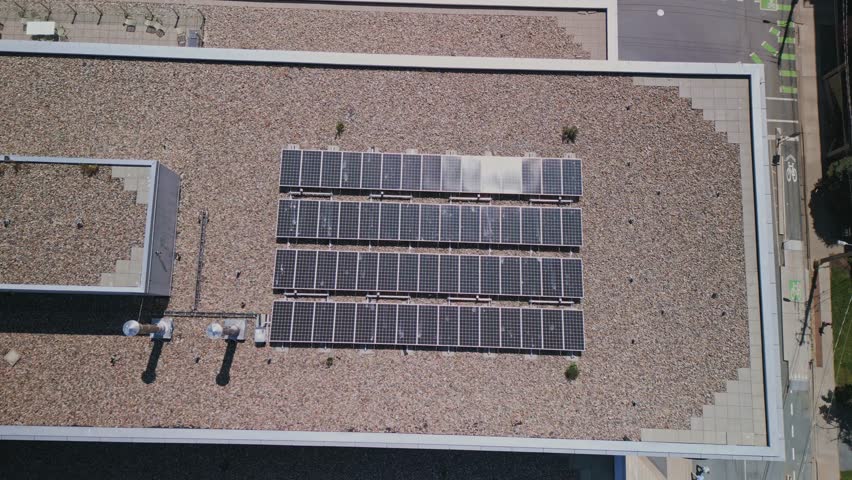 Drone shot of an array of solar panels installed on an apartment building in downtown Halifax, Canada. Drone view of a modern rooftop photovoltaic power system. Royalty-Free Stock Footage #1107814179