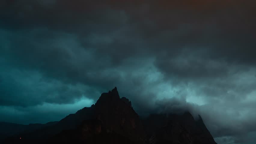 Intense lightning thunderstorm flash and dramatic dark clouds moving fast over mountain peak in Dolomites. Night sky during a strong summer storm in Italy. Natural disasters and climate change Royalty-Free Stock Footage #1107815795
