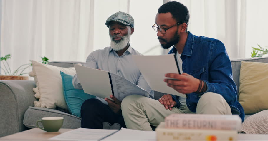 Planning, father and son with paperwork, conversation and pension fund with retirement, home or communication. Family, black men or dad with adult on a couch or documents for insurance or real estate Royalty-Free Stock Footage #1107822589