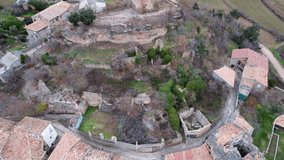 Panoramic drone view of old medieval Romanesque church of San Cristobal and view of surrounding area and tile roofs of houses of Luzas, example of ancient architecture. Huesca, Aragon, Spain. 4K video