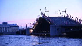 Side view of opening bascule bridge at twilight (early morning) in Saint Petersburg city, Russia. Transportation uilding. Real time video. Russian text on flags translation: fire department.