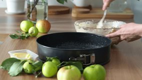 Pour the dough mixed with apples into a metal baking dish. Autumn mood to cook homemade cakes. Cooking video tutorial. Food preparation process. Cooking in the kitchen at home.