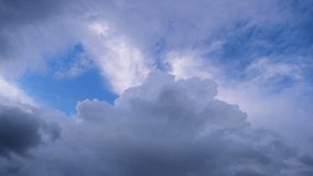 Timelapse of dark clouds filling in white clouds in a blue sky. Video starts with white clouds and slowly dark clouds take the charge to vanquish white cloud.