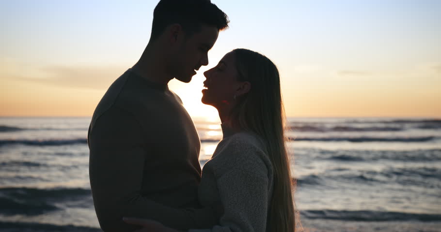 Silhouette, couple and travel, sunset at the beach and love with bonding, romantic date outdoor with hug or dancing. Man, woman and healthy relationship with adventure, forehead touch, sea and trust Royalty-Free Stock Footage #1107838095