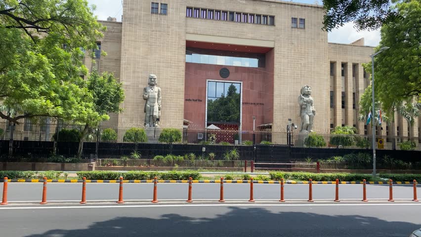 A shot of Reserve Bank of India RBI logos with two statue and in front of building traffic is going outside of RBI building at New Delhi, India Royalty-Free Stock Footage #1107839883