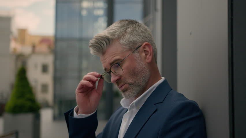 Mature Caucasian senior man male employer entrepreneur retired old middle-aged pensive thinking businessman trader using computer think take off glasses typing laptop outdoors in city business idea Royalty-Free Stock Footage #1107842325