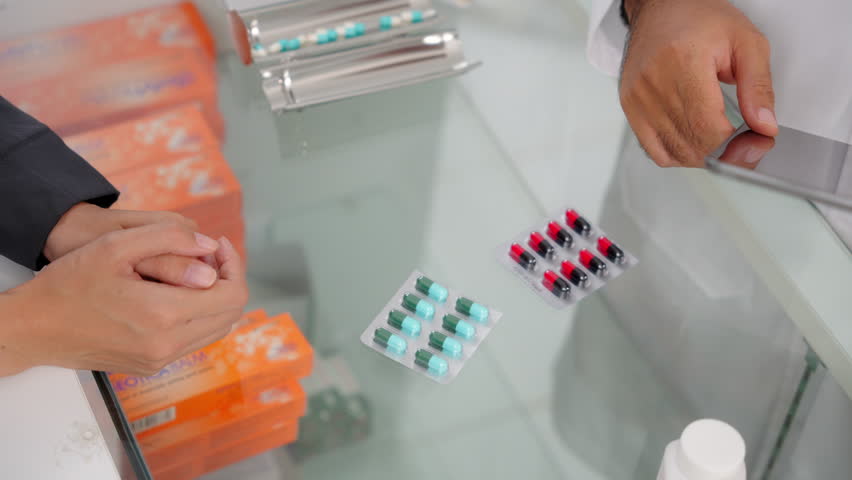 Close up hands of Handsome asian male selling pharmacist and female customer buying medicine in the pharmacy drugstore, hand over capsule pills of medicine from hand to another hand charge. Royalty-Free Stock Footage #1107844021