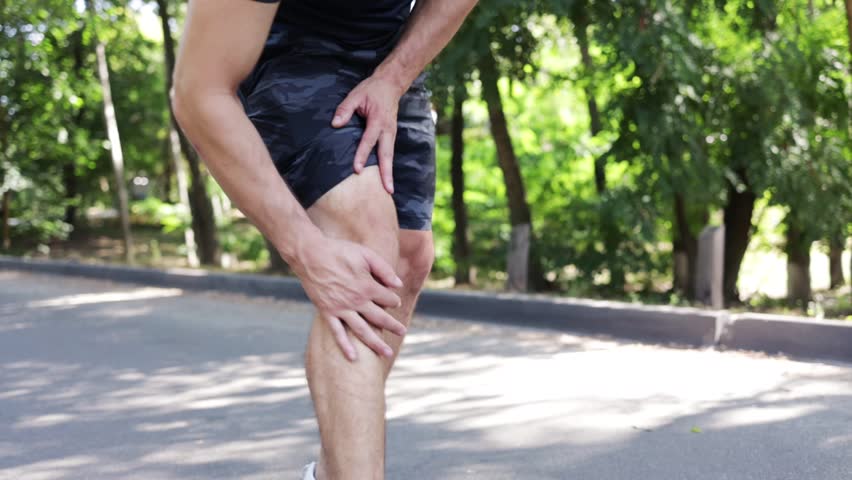 Injury and pain in the knee of a male runner. Fitness man runner feel pain on knee. Royalty-Free Stock Footage #1107847397