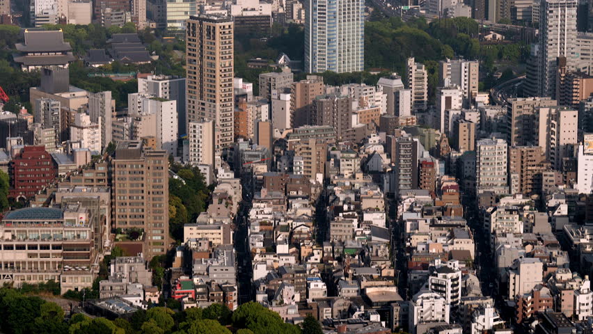 Aerial tilt up from houses to towers and bay. Tokyo, Japan.