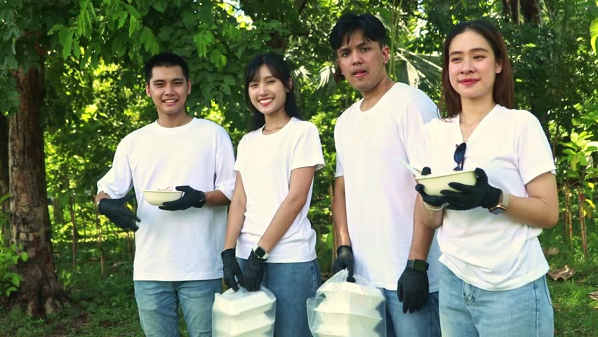 Asian group working social volunteers donate food, rice, fried eggs and boxed meals. Standing and greeting, willing help the society, feeding the volunteers who participated forest planting activity. Royalty-Free Stock Footage #1107850351