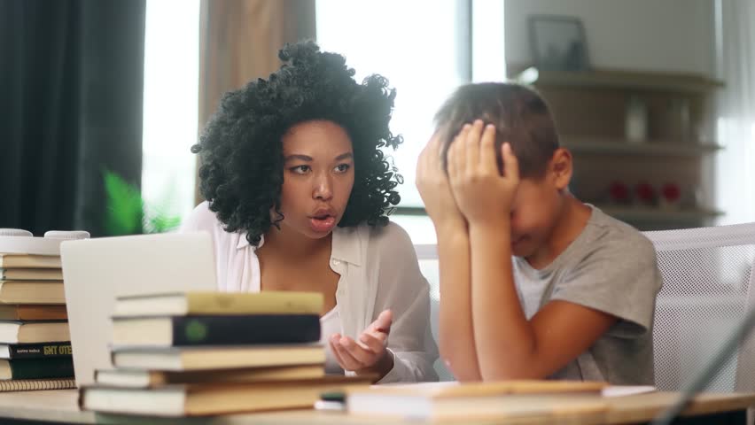Sad primary school boy kid feeling upset while his mother screaming at him because studying at home Angry mad woman mom doing homework together with aggressive indoors Stress education concept Royalty-Free Stock Footage #1107850509