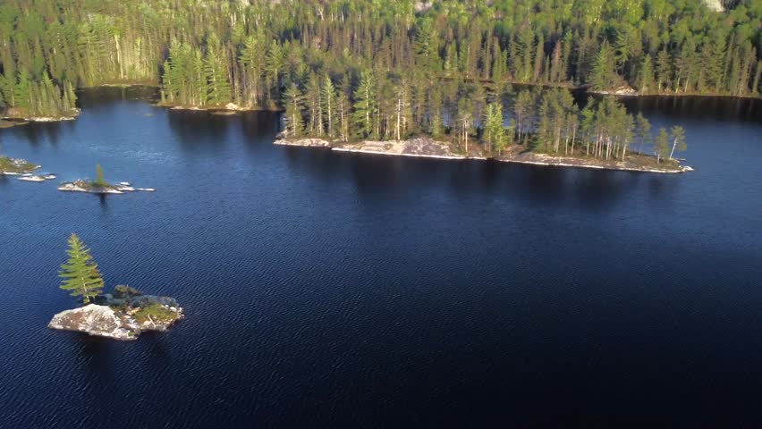 An aerial view of a lake surrounded by trees in Northern Ontario, Canada