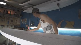 Male surfboard shaper making surfboard in his workshop. Hand shaping from blank. - Powered by Shutterstock - Get 15% off with code: PIKWIZARD15