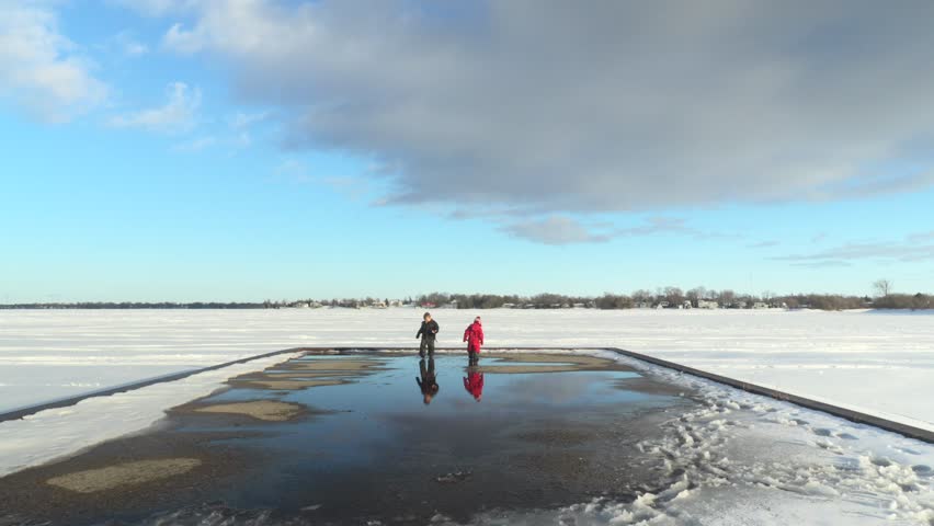 A timelapse of two kids playing outdoors with a snowy field and blue sky in the background