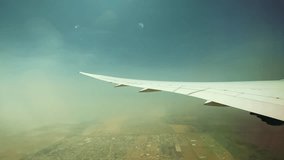 Video from the plane on its wing, the land of Dubai beneath it and a dust storm on the horizon