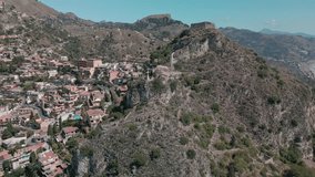Soar above Taormina, Sicily, and witness a panorama that encapsulates the city's allure. From the enchanting mountains to the azure sea and vibrant city, this aerial journey is a visual feast