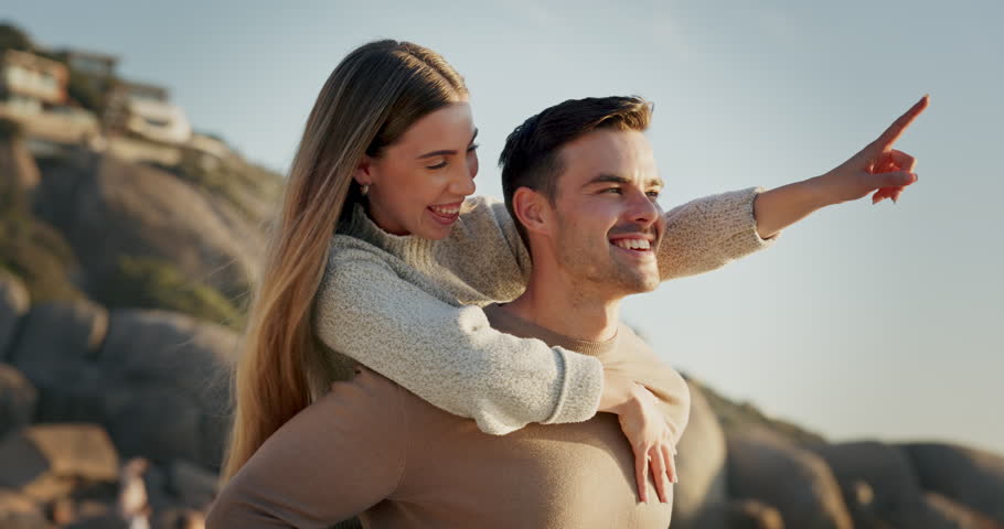Piggyback, couple and travel, happiness at the beach and love with bonding, romantic date outdoor and hug. Man, woman and healthy relationship with adventure, journey and walking, freedom and view Royalty-Free Stock Footage #1107862301