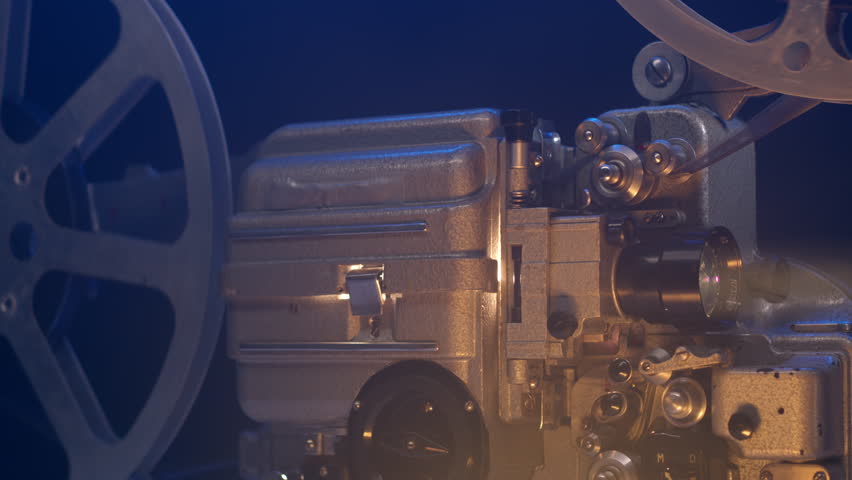 Close up view of old vintage movie projector playing film and camera move around it. 16mm retro projector. The concept of old film or cinema. beam of light illuminates in dark. Royalty-Free Stock Footage #1107862881