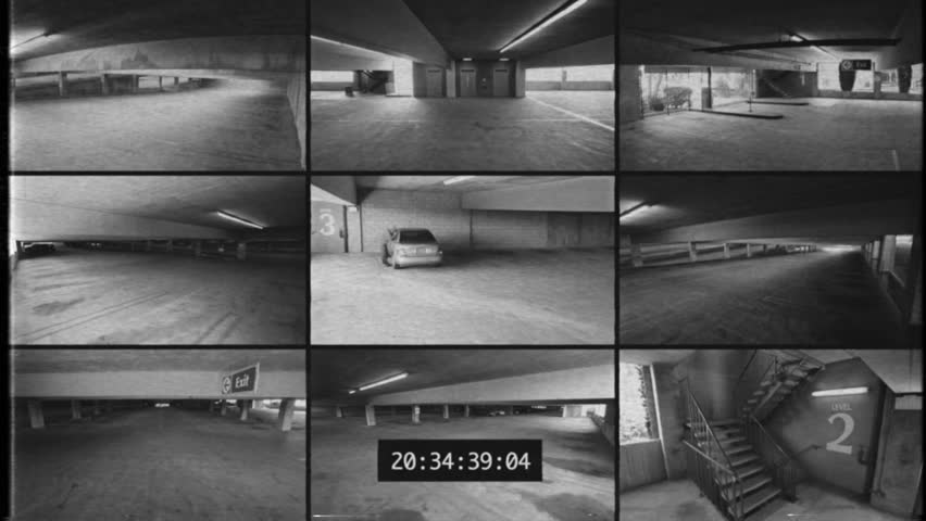 Security camera footage of a car in a parking deck being broken into. Royalty-Free Stock Footage #1107863069