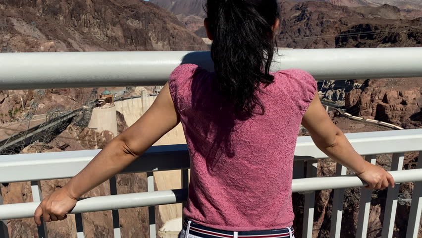 Asian woman enjoys the view of Hoover Dam on the border of Nevada and Arizona.