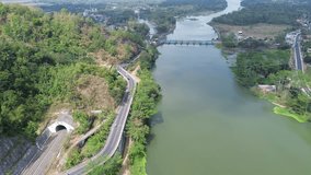 4k aerial footage drone view of the highway by the river with mountains and trees in the background