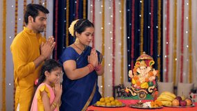 A modern Indian family prays to Lord Ganesh on Ganesh Chaturthi - ethnic wear, Indian rituals, colorful decorations . Stock video of a female dressed in ethnic saree worshipping Lord Ganpati on Gan...