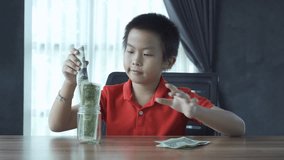 boy put a bank note into bottle, 4k footage