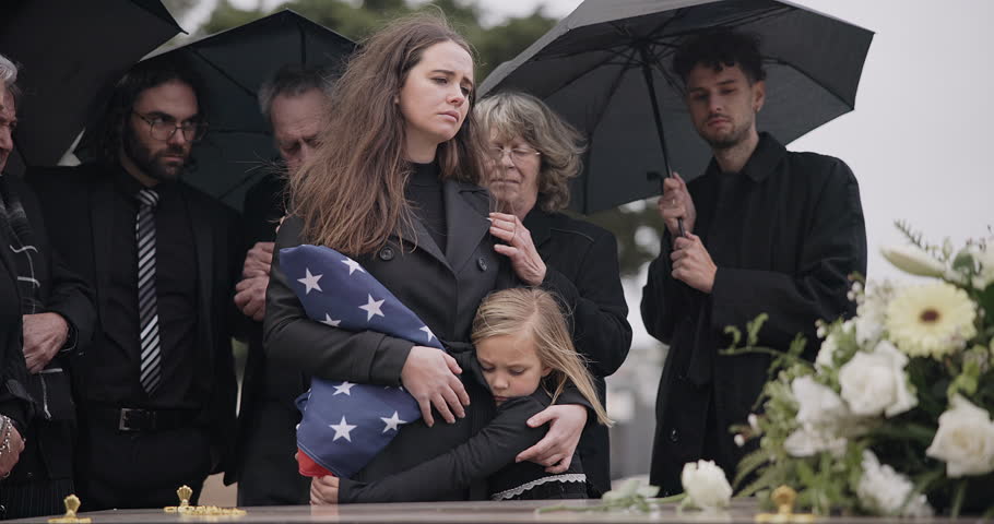 Funeral, family hug and sad people with grief support, goodbye service and mourning death at burial event. Kid child, mom embrace and group gathering together at coffin, casket and crying at ceremony Royalty-Free Stock Footage #1107873667