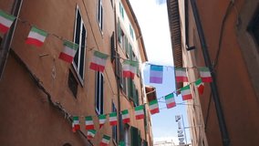 Facade of a yellow building with Italian flags. Holiday in the Italian city of streets with Italian flags and ancient buildings. Pisa, Italy. . High quality FullHD footage - Powered by Shutterstock - Get 15% off with code: PIKWIZARD15