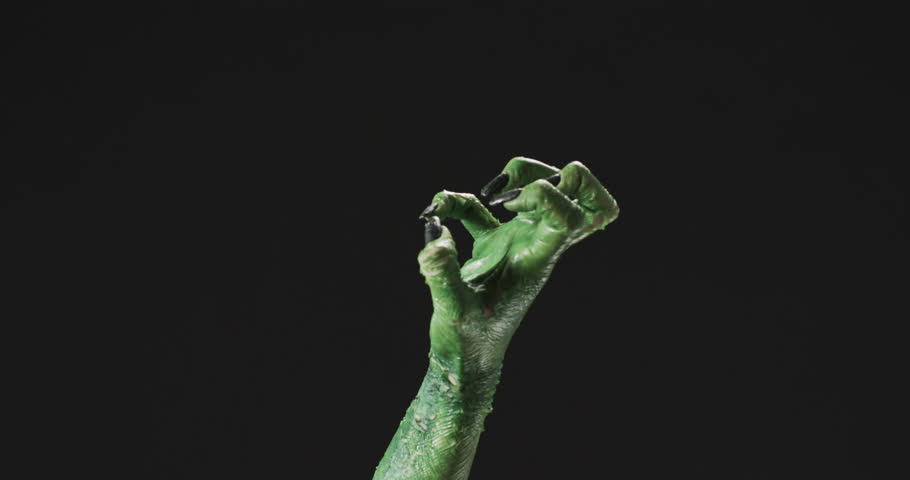 Video of halloween green monster hand with copy space on black background. Halloween, tradition and celebration concept.
