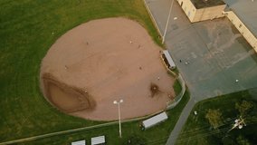 Drone shot down on a baseball field with a team of uniformed players. Aerial view of baseball players during a baseball game hitting the ball with a baseball bat and running players.  - Powered by Shutterstock - Get 15% off with code: PIKWIZARD15