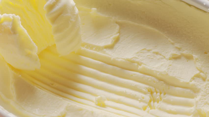 Butter is scraped off with a special butter knife from a pack of butter into a recognizable shape. Royalty-Free Stock Footage #1107881155