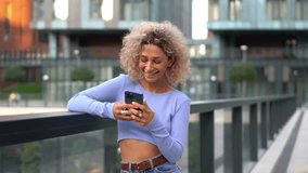 Happy Caucasian woman using cellular application for chatting in social networks, cheerful hipster girl enjoying online browsing on modern smartphone gadget connecting to 4g wireless internet