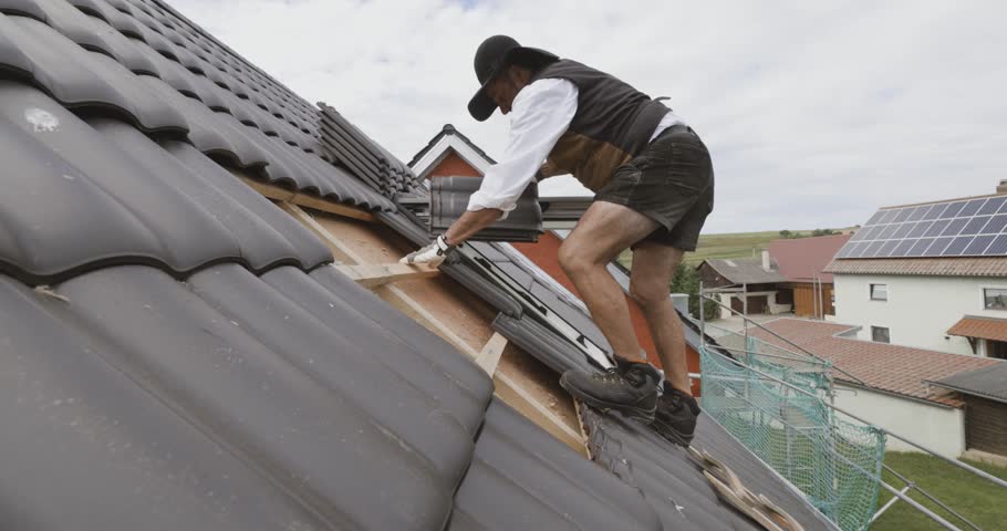 Roofer working on roof on a private home Royalty-Free Stock Footage #1107889239